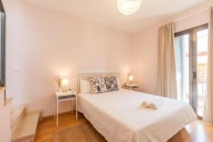 a white bedroom with a large bed and a window at Freedom Penthouse in Seville