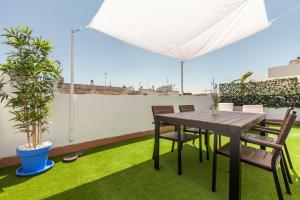 a table and chairs on a patio with grass at Freedom Penthouse in Seville