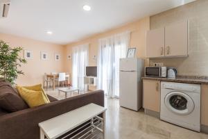 a kitchen and living room with a couch and a washer at Freedom Penthouse in Seville