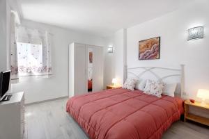 a bedroom with a red bed and a television at Apartamento La Concha in Candelaria +20 photos