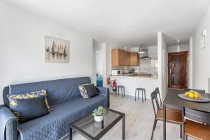 a living room with a blue couch and a table at Apartamento La Concha in Candelaria