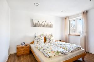 a white bedroom with a bed and a window at Ferienwohnung Seyfried in Hardheim