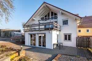 a white house with a balcony on it at Ferienwohnung Seyfried in Hardheim