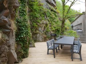 a table and chairs sitting next to a stone wall at Vacance 16 Pers in La Bourboule