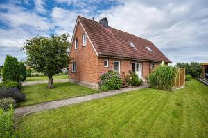 a red brick house with a green yard at Ferienwohnung Meeresbrise in Grömitz