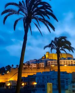 a view of a city from between two palm trees at Perlazul in Peniscola