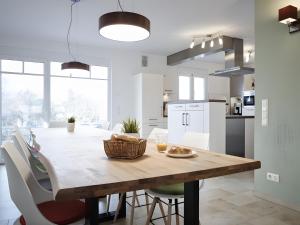 a kitchen and dining room with a wooden table and chairs at Ferienhaus Elsa 180 qm in Rust
