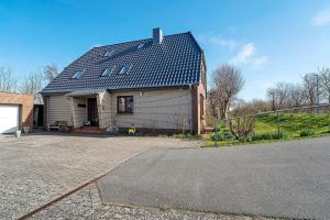 a large house with a gambrel roof on a driveway at Fischerhus Anne Jensen in Pellworm