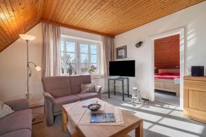 a living room with a couch and a bed at Fischerhus Anne Jensen in Pellworm