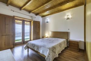 a bedroom with a bed and a large window at Casa De Basto in Gémeos +12 photos