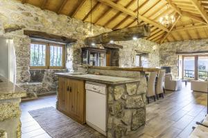 a kitchen with stone walls and a counter with a sink at Casa De Basto in Gémeos