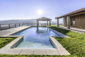 a swimming pool with a gazebo next to a house at Casa De Basto in Gémeos