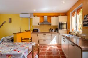 a kitchen with yellow walls and a table in a room at Appartement N°3 - Piscine Partagée in Lagorce