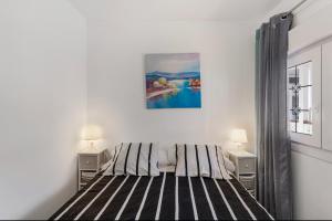 a white bedroom with a bed with two night stands at Casa Paula - 21 in Arinaga +20 photos