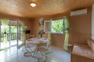 a dining room with a table and chairs and windows at Maison Jordan - Mas Lachamp in Gravières
