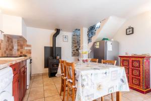 a kitchen with a table with chairs and a refrigerator at La Fenière - Maison avec terrasse in Collobrières +20 photos