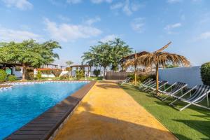 a swimming pool with lounge chairs next to a house at Finca Los Caleros - Algorfa in Algorfa