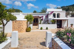 a white house with a courtyard with flowers at Can Pep Den Sitges in Sant Joan de Labritja