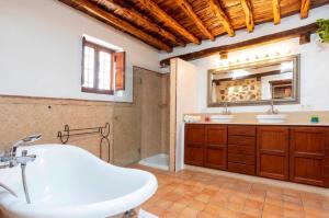 a bathroom with a tub and a sink and a mirror at Can Pep Den Sitges in Sant Joan de Labritja +34 photos