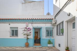 a blue and white house with a tree in front of it at Casa Buganvilla in Barbate