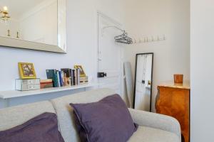a living room with a couch and a mirror at Joli studio près de Monaco in Beausoleil