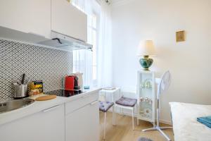 a white kitchen with a sink and a refrigerator at Joli studio près de Monaco in Beausoleil