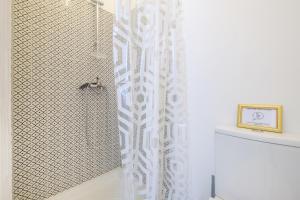 a shower with a white shower curtain in a bathroom at Joli studio près de Monaco in Beausoleil +15 photos