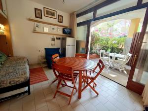 a room with a wooden table and chairs and a bedroom at App Casa Dei Pini - Bilocale in Capoliveri