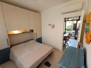 a small bedroom with a bed and a table at App Casa Dei Pini - Bilocale in Capoliveri
