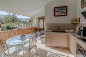 a kitchen with a glass table and a large window at Gite du Moulin - Ariège in Carla-de-Roquefort +15 photos