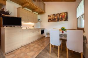 a kitchen with white cabinets and a table and chairs at Kreuzhof links in Novacella