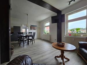 a living room and dining room with a table and chairs at Apartment - Tor zur Rhön in Vachat +2 photos
