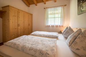 a bedroom with two beds and a window at Kreuzhof links in Novacella
