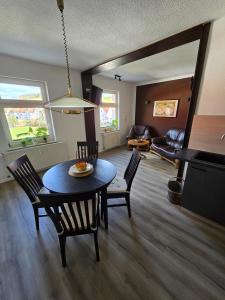 a dining room and living room with a table and chairs at Apartment - Tor zur Rhön in Vachat