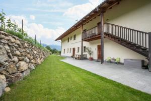 a stone wall next to a building with a patio at Kreuzhof links in Novacella