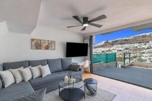 a living room with a couch and a ceiling fan at Arizona's Bay in Puerto Rico de Gran Canaria