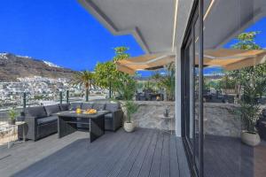 a patio with a table and chairs on a deck at Arizona's Bay in Puerto Rico de Gran Canaria