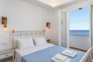 a bedroom with a bed with a view of the ocean at Blue Waves View Andros in Andros
