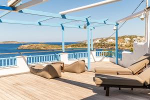 a deck with chairs and a view of the ocean at Blue Waves View Andros in Andros