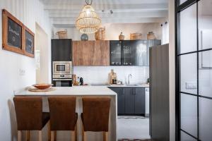 a kitchen with a large island with bar chairs at Casa Roques 16 in Jávea +17 photos