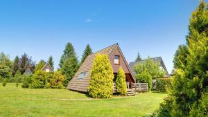 a house on a lawn with trees in front of it at Ferienhaus Auszeit mit Terrasse in Tennenbronn