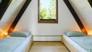 two beds in a room with a window at Ferienhaus Auszeit mit Terrasse in Tennenbronn +18 photos