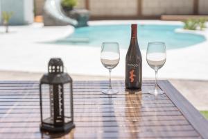 a bottle of wine and two wine glasses on a table at Casa Abuelo Manuel in El Draguito