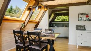a dining room with a table and some windows at Ferienhaus Auszeit mit Terrasse in Tennenbronn