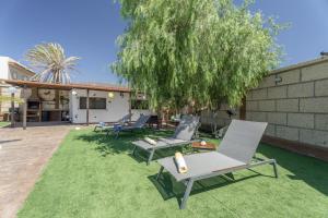a yard with two chairs and a tree at Casa Abuelo Manuel in El Draguito