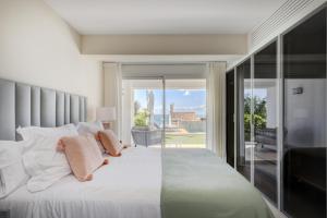 a bedroom with a large white bed and a sliding glass door at Villa Endless Summer in Estepona +32 photos