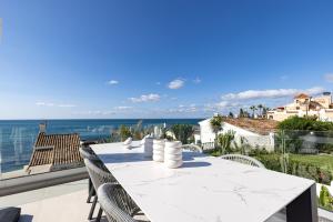 a table with chairs and a view of the ocean at Villa Endless Summer in Estepona