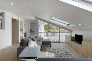 a living room with a couch and a tv at Sky and Sea Haven in Santa Cruz