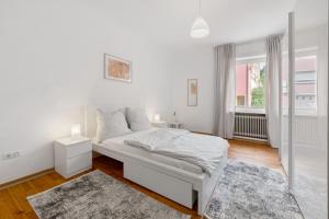 a white bedroom with a bed and a window at Ferienwohnung Merzig in Merzig