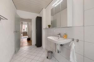 a white bathroom with a sink and a mirror at Ferienwohnung Merzig in Merzig +15 photos